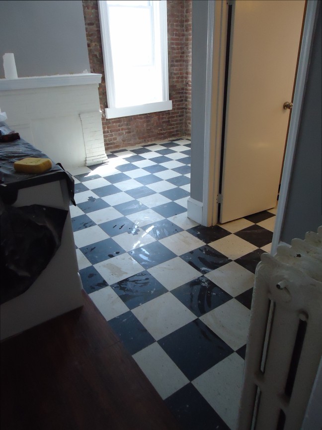 Ancien carrelage noir et blanc dans une pièce en cours de rénovation.
