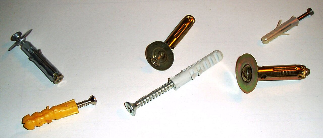 Assortiment de chevilles en plastique et de fixations métalliques pour parois creuses.